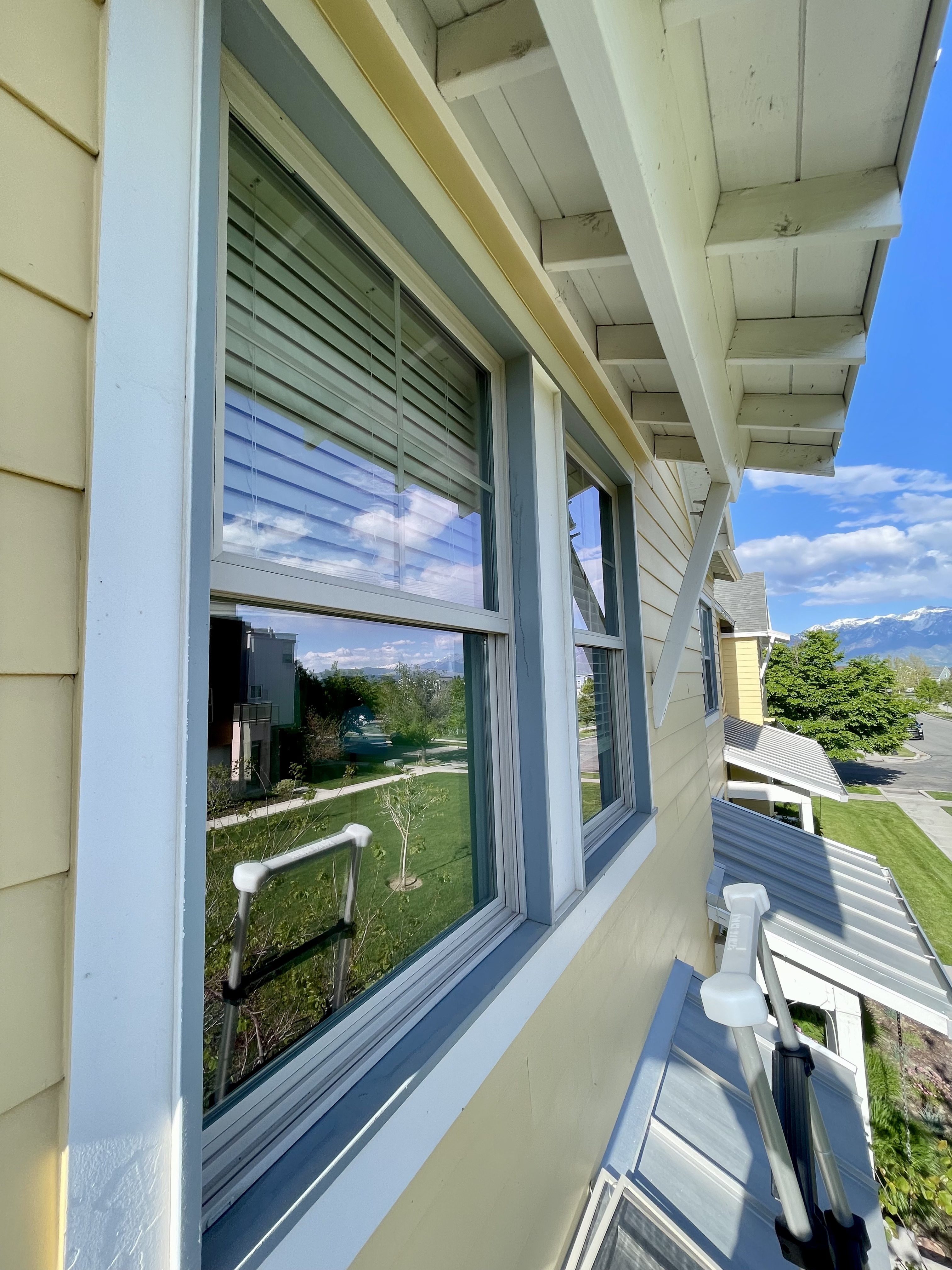 Same exterior windows with sharp reflections of blue sky and mountains